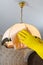 Hands in rubber gloves wiping dust from the chandelier. House cleaning, cleaning service. Household concept