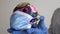 Hands in rubber medical gloves holding decorated colorful skulls wearing a blue surgical mask