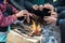 Hands of rural minority people warming up around the fire during the cold weather days in mountaious region in Vietnam