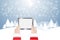 Hands of Santa Claus holding tablet in winter landscape