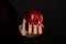 Hands with scary nails manicure holding poisoned red apple