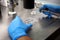 Hands of a scientist in the laboratory with a test tube and a microscope. The invention of the vaccine, a doctor in the clinic of