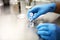 Hands of a scientist in the laboratory with a test tube and a microscope. The invention of the vaccine  a doctor in the clinic of