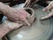 The Hands are sculpting the clay into the desired shape. Is one of the process of making pottery