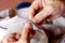 Hands of seamstress at work on the wooden chair with her cloth , hand made soft toys sewing with felt and needle..