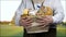 Hands of senior farmer holding basket of dairy products.