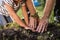 Hands of senior man with granddaughter gardening outside