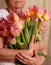 Hands of a senior woman holding flower bouquet. mother`s day greeting card, women`s day or grandmothers day. Older Persons Day