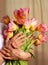 Hands of a senior woman holding flower bouquet. mother`s day greeting card, women`s day or grandmothers day. Older Persons Day