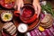 hands serving a colorful plate of borscht soup and rye bread