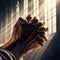 Hands set in praying position, as light beans from church window