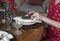 Hands setting and decorating dining table for festive winter dinner. Closeup of white napkin and red berries for