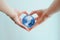 Hands in shape of heart  holding blue glass globe of South Pole