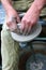 Hands shaping clay on potter\'s wheel