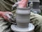 Hands shaping clay on potter\'s wheel