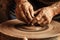 hands shaping clay on pottery wheel