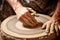 hands shaping clay on pottery wheel