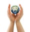 Hands sheltering tiny globe facing Asia