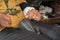 Hands of a shoemaker sews old sandals in the street shop.