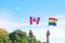 Hands showing LGBTQ Rainbow and Canada flag on nature background. Support Lesbian, Gay, Bisexual, Transgender and Queer community