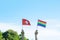 Hands showing LGBTQ Rainbow and Switzerland flag on nature background. Support Lesbian, Gay, Bisexual, Transgender and Queer