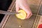 Hands slicing lemon with knife.