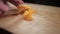 Hands slicing peeled peaches on a cutting board