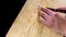 Hands slicing peeled peaches on a wooden cutting board