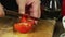 Hands slicing tomato in kitchen