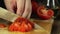 Hands slicing tomato in kitchen