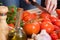 Hands slicing tomatoes at table