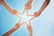 Hands, star and teamwork with friends in a huddle on a clear blue sky background from below. Trust, support and