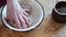 Hands are stirring minced meat in a bowl