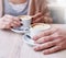 Hands on the table holding cups of coffee