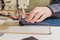 hands of a tailor seamstress at work in the shop for a sewing machine industrial, clothing production, loom