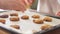 Hands take fresh hot cookies from baking sheet. Woman\'s, men\'s and child hands take fresh home cookies. Many