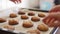 Hands take fresh hot cookies from baking sheet. Woman\'s, men\'s and child hands take fresh home cookies. Many