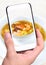 Hands taking photo salmon soup, shrimp with smartphone