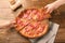 Hands taking pizza slices on wooden table