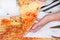 Hands taking slices of pizza Margarita. Hand drawn on pieces of delicious pizza, close up. Italian traditional classic pizza.