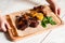 Hands taking wooden tray with barbecue from table