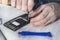 Hands of a telephone service employee unscrews the inside the mobile phone.