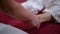 Hands of Thai spa therapist massaging feet of woman