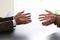 Hands from two businessmen in conversation by a desk. Negotiating business or a job interview. - Image