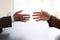 Hands from two businessmen in conversation by a desk about to shake hands. Negotiating business or a job interview. - Image