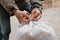 Hands tying white bag in yard