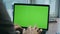 Hands typing green screen computer writing text on keyboard at workplace closeup