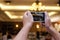 Hands of unidentified people taking photo of dinner party with mobile smart phone