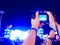 Hands of unidentified record video with digital camera during music festival concert