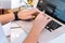 Hands of unrecognisable woman sitting in office coworking and typing on her laptop keyboard computer